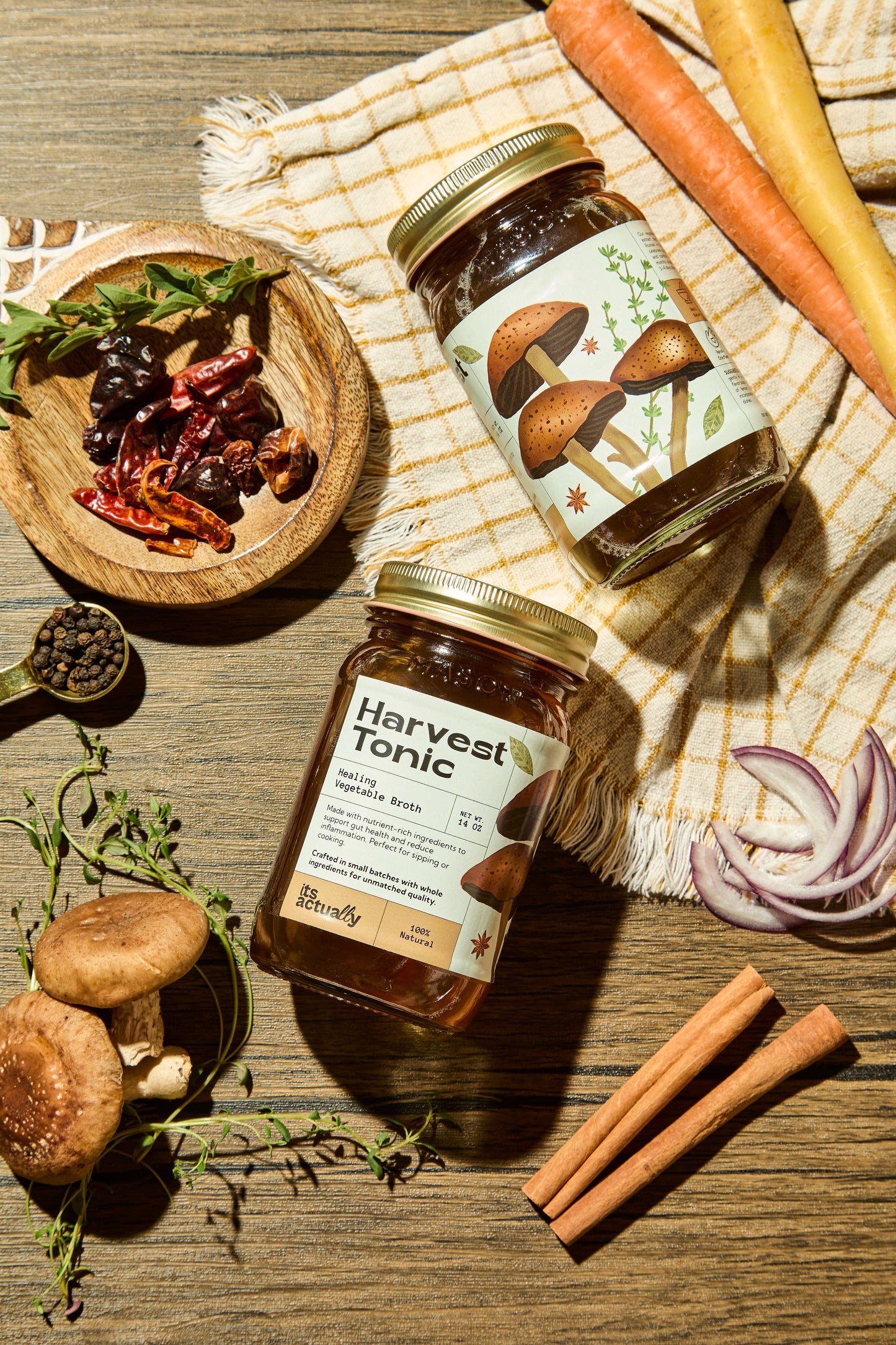 Three 14oz jars of Its Actually Co. Healing Vegetable Broth beverage, showcasing fresh ingredients in clear glass jars.