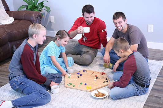 Hand painted Aggravation Wahoo marble board game on wooden surface, double-sided with colorful marble pathways and game pieces.