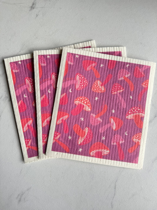 Set of three purple mushroom Swedish dish cloths by Meli Wraps, reusable kitchen cleaning cloths with vibrant mushroom pattern.