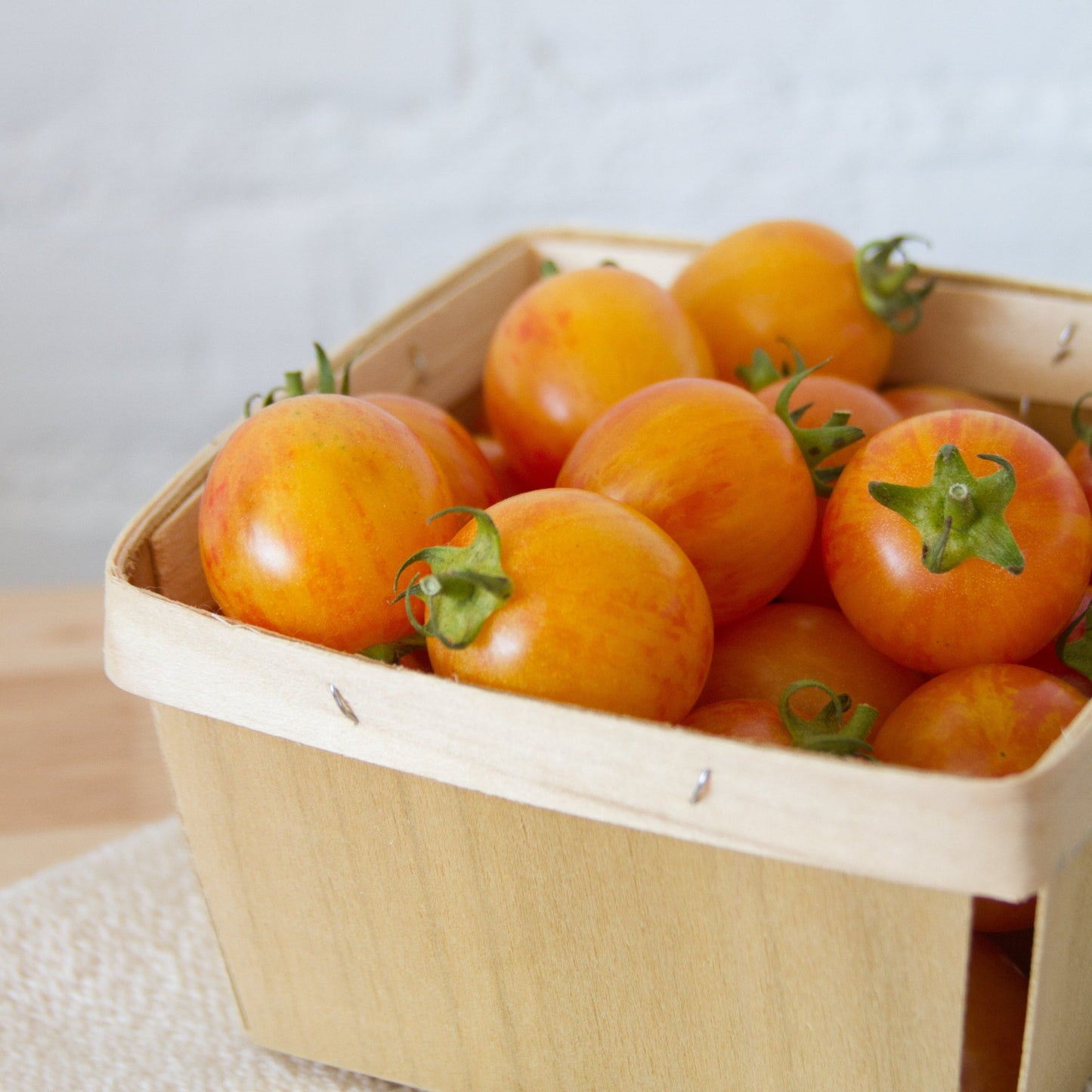 Bright image of a Tropical Sunset Tomato from MIgardener, showcasing its vibrant orange and yellow ripe fruit on the vine.