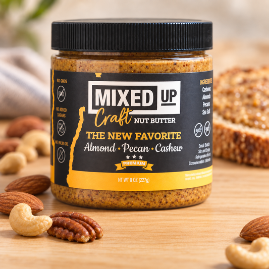 Almond, pecan, and cashew nut butter jar from Mixed Up Foods labeled "The New Favorite" 8 oz with a natural nut spread background.