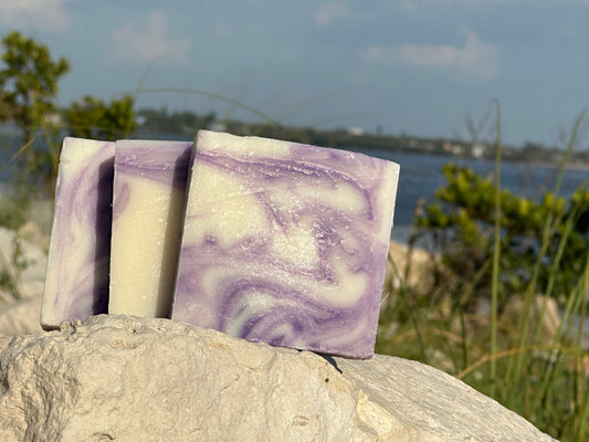Lavender soap by Peachy Clean Soaps and More LLC showing a bar of soap with lavender flowers and a calming lavender scent.