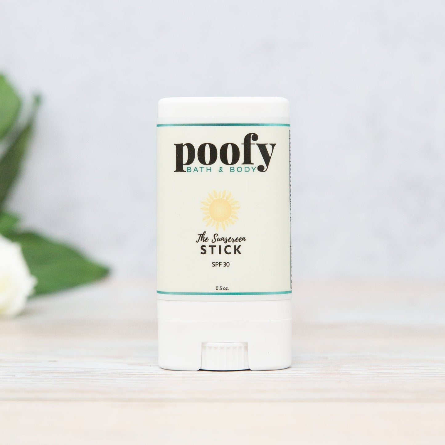 Poofy Organics Sunscreen Stick for outdoor use, featuring a white stick with SPF protection in a natural outdoor setting.