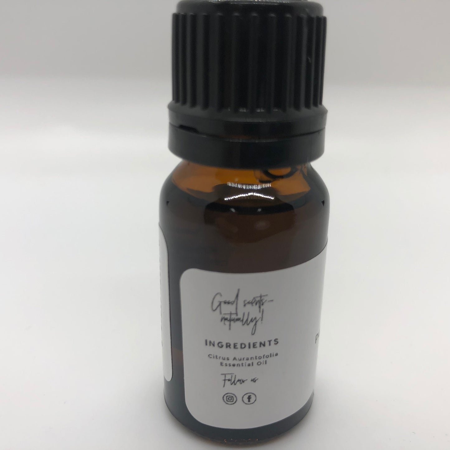 Lime essential oil in a 10 ml bottle from Prairie Fire Tallow, Candles, and Lavender, with fresh lime slices and botanical background.
