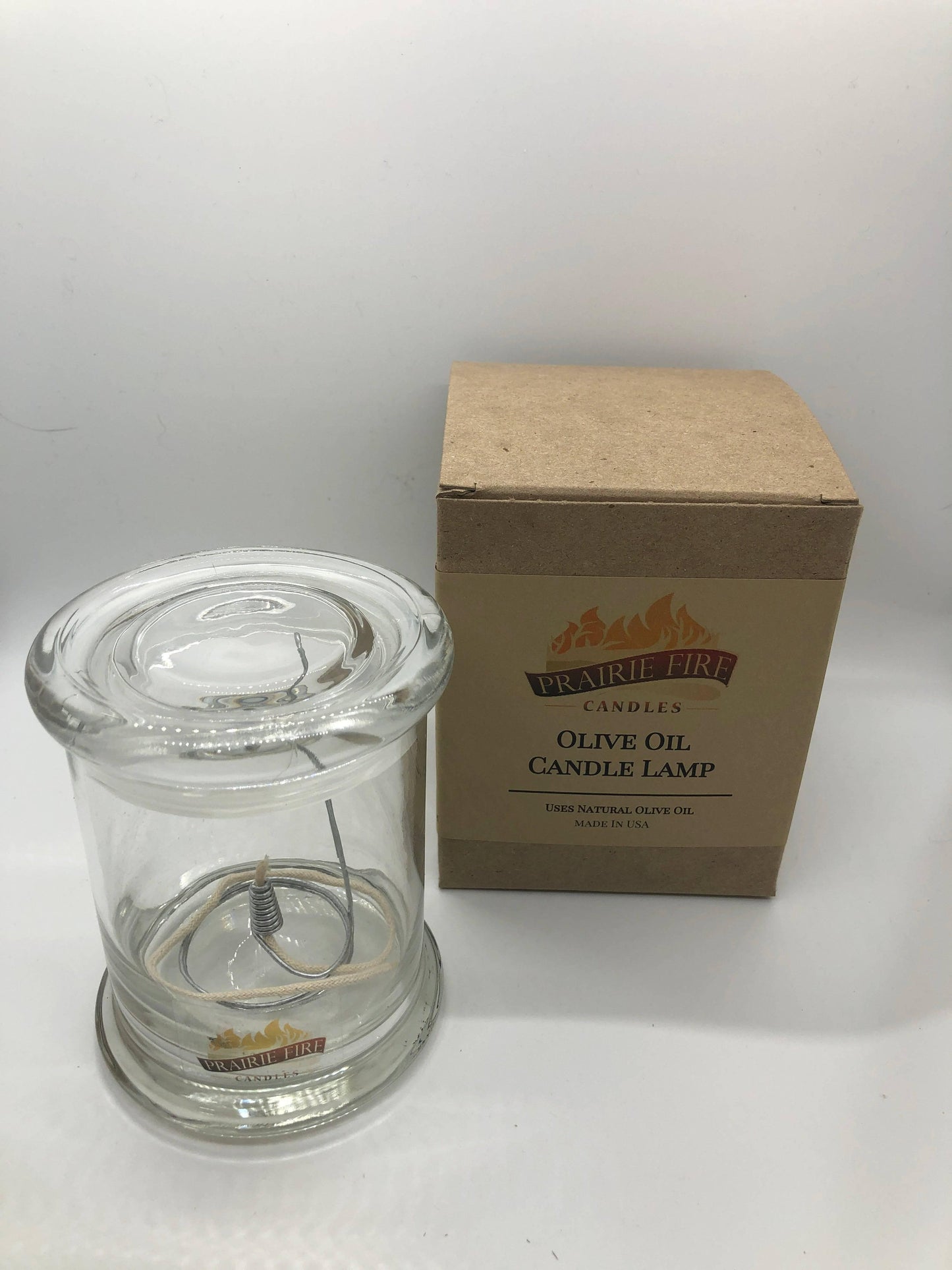 Olive Oil Candle Lamp from Prairie Fire Tallow, used as an emergency backup during power outages, with a rustic design and glass container.
