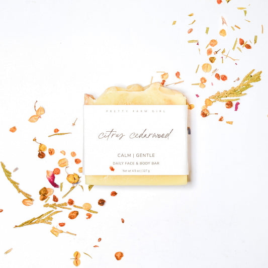 Handmade citrus cedarwood soap bar by Pretty Farm Girl featuring tallow and goat milk, shown with fresh citrus and cedarwood.
