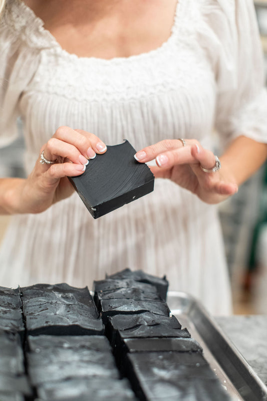 Handmade charcoal and goat milk soap bar by Pretty Farm Girl, featuring a natural, textured surface and rustic packaging.