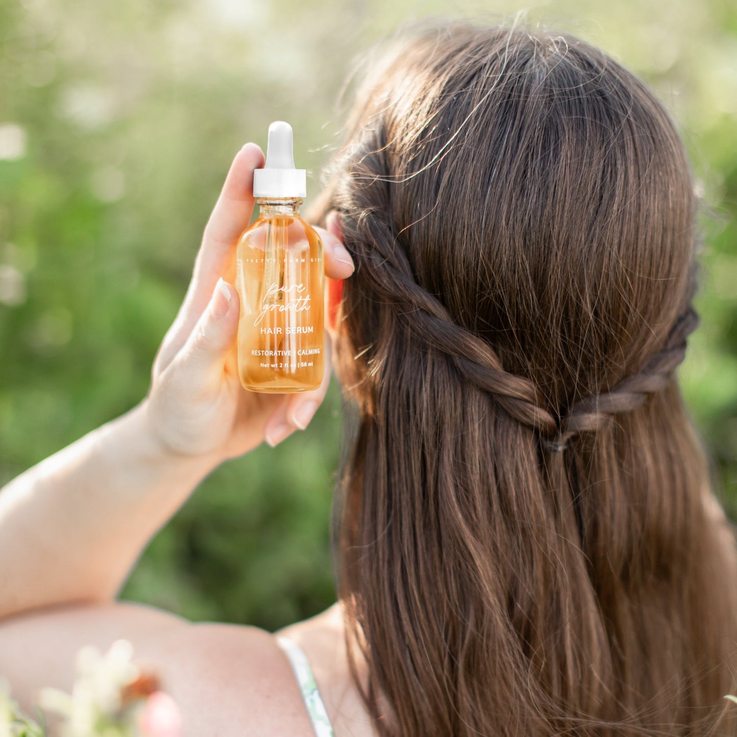 Bottle of Pretty Farm Girl Pure Growth Hair Serum, a scalp and hair oil designed to promote healthy hair growth.
