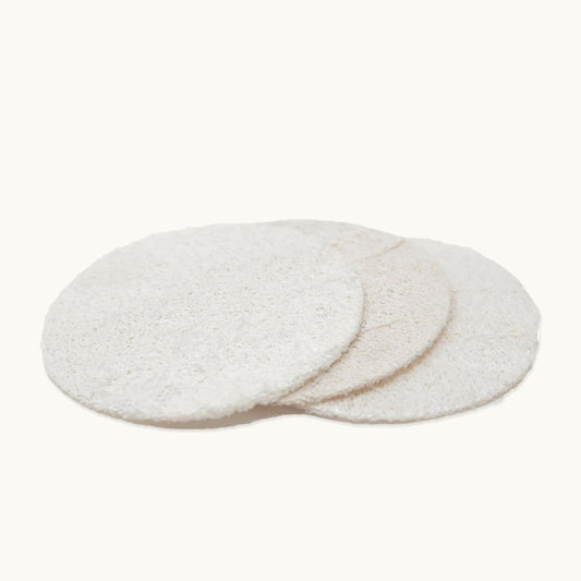 Three round, off-white Loofah Facial Discs from ZeroWasteStore.com are stacked on a light background. These exfoliating, compostable pads refresh your skin and offer an eco-friendly facial care option.
