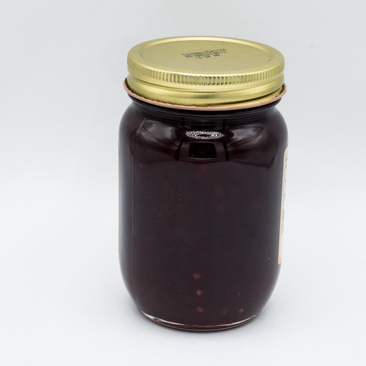 Canned Amish Country Store Red Raspberry Seedless Jam in 18oz jar, bright red fruit spread with smooth texture.