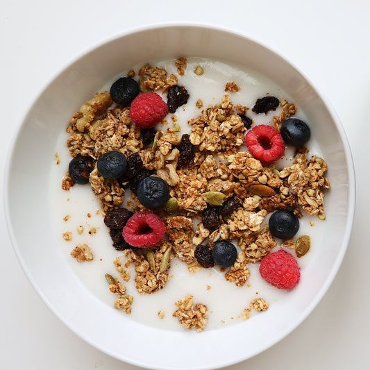 Rooted Living Maple Almond Granola in a bowl, showcasing toasted oats, almonds, and maple syrup for a hearty breakfast.