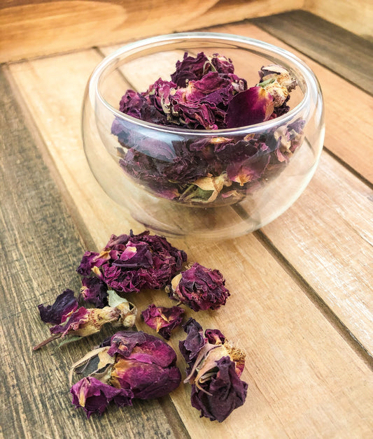 Fresh pink rose petals from Herbal Rose Apothecary, arranged in a delicate pile on a white background.