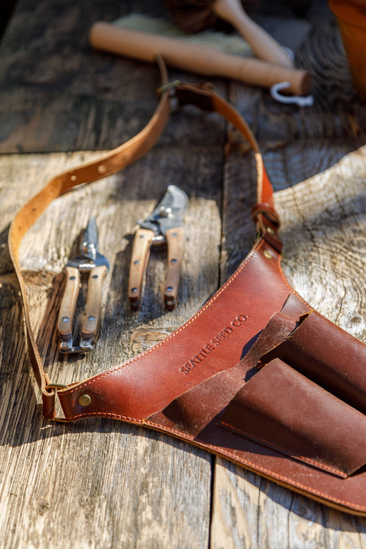 Genuine leather gardener's tool belt from Harvest Essentials by Seattle Seed Company, designed for gardening and outdoor work.