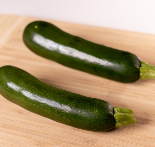 Packet of Spineless Supreme Hybrid Zucchini Seeds by Seeds 'n Such, showing seed packets with images of zucchini plants