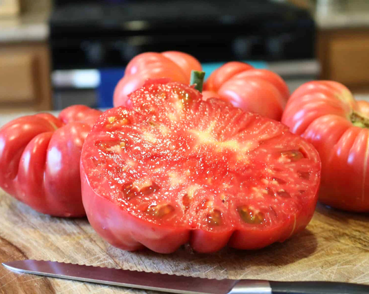 Pink Delicious Hybrid Tomato Seeds from Seeds 'n Such in a packet of 10 seeds, showcasing vibrant pink tomato seed packets.
