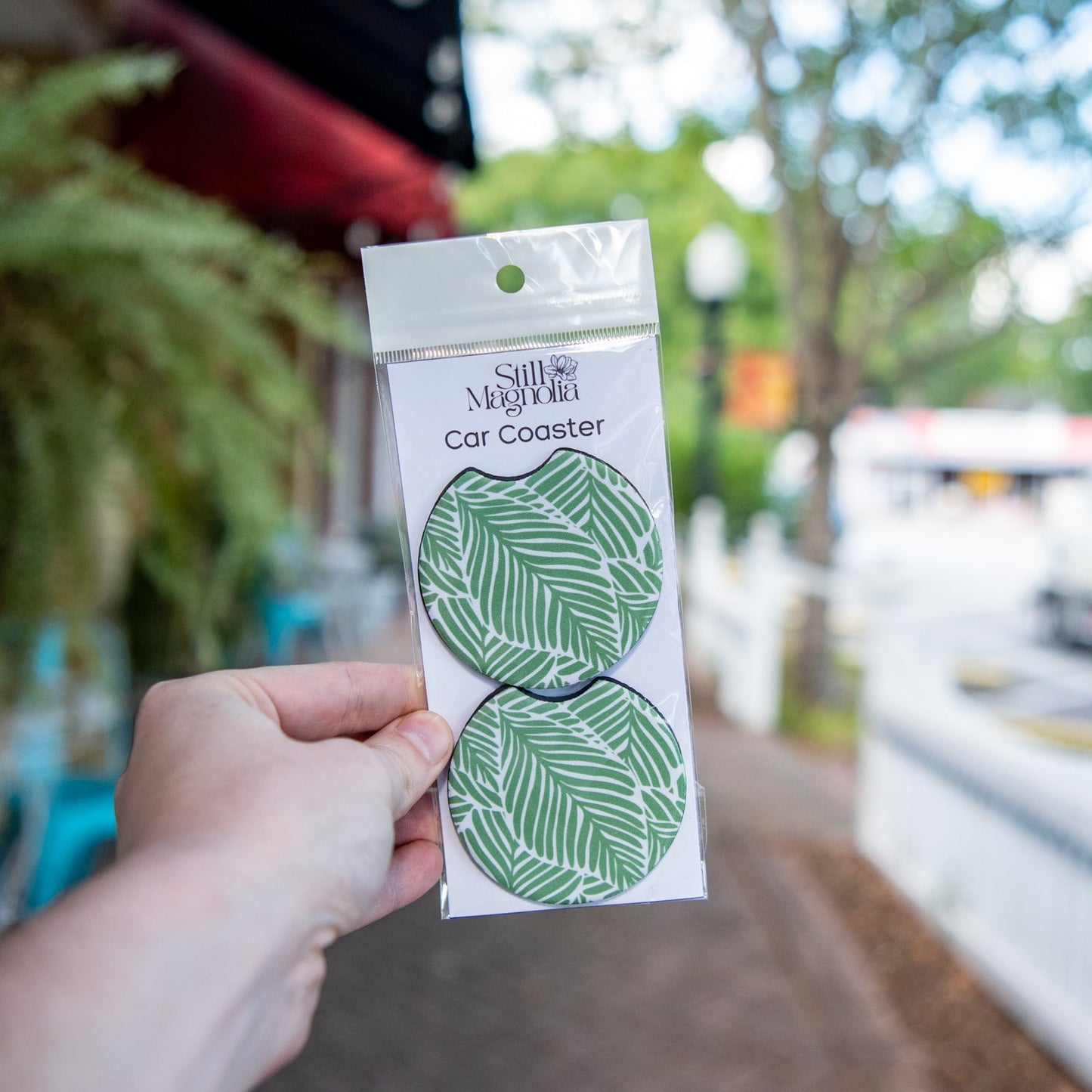 Still Magnolia Leafy Luxe car coaster with leafy green design, made of absorbent material for vehicle cup holders.
