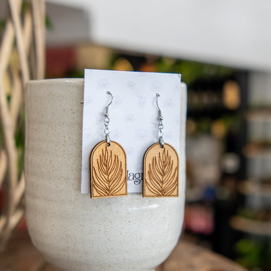 Still Magnolia palm leaf arched earrings featuring gold-tone metal and leaf-shaped design, perfect for stylish accessories.
