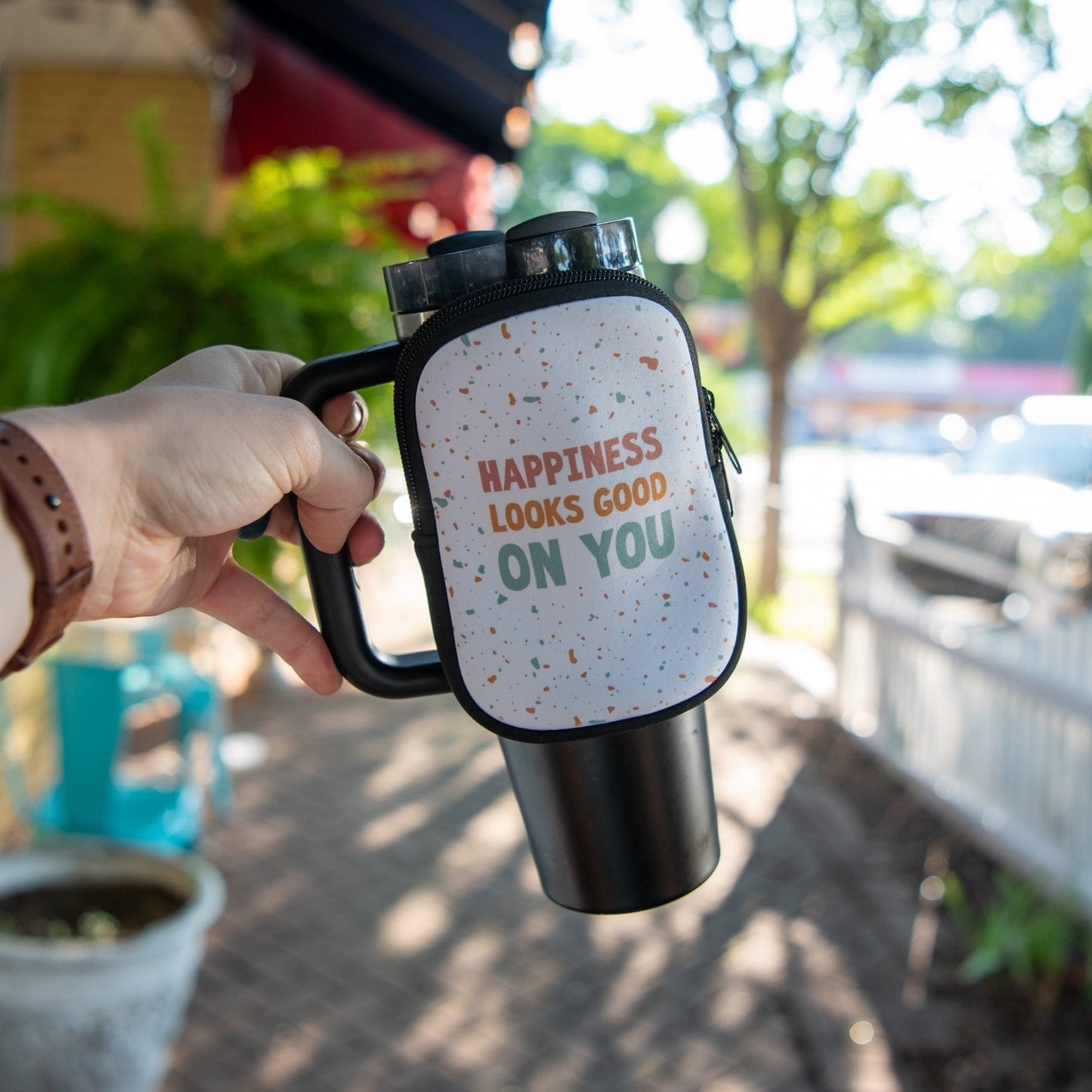 Still Magnolia tumbler pouch with "Happiness Looks Good on You" print, designed to hold and protect your tumbler or drinkware.
