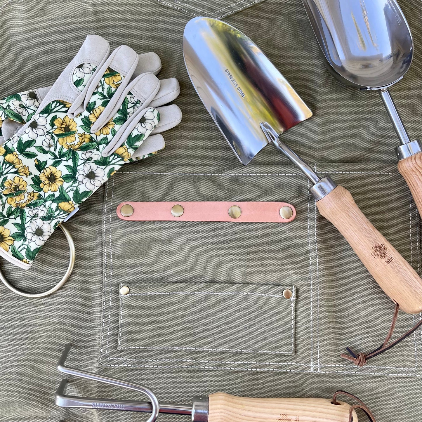 Dark green waxed canvas gardening apron with multiple pockets by The Celtic Farm, designed for gardening and outdoor work.