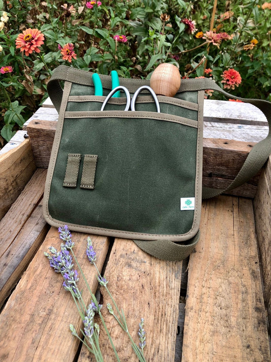 Waxed canvas garden tool belt by The Celtic Farm, hunter green, designed for gardening with multiple tool pockets.