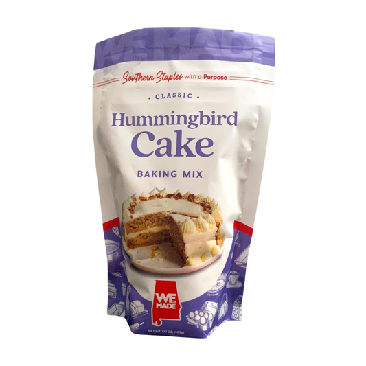 Box of WE Made Hummingbird Cake Mix with colorful packaging and images of the prepared cake on the front.