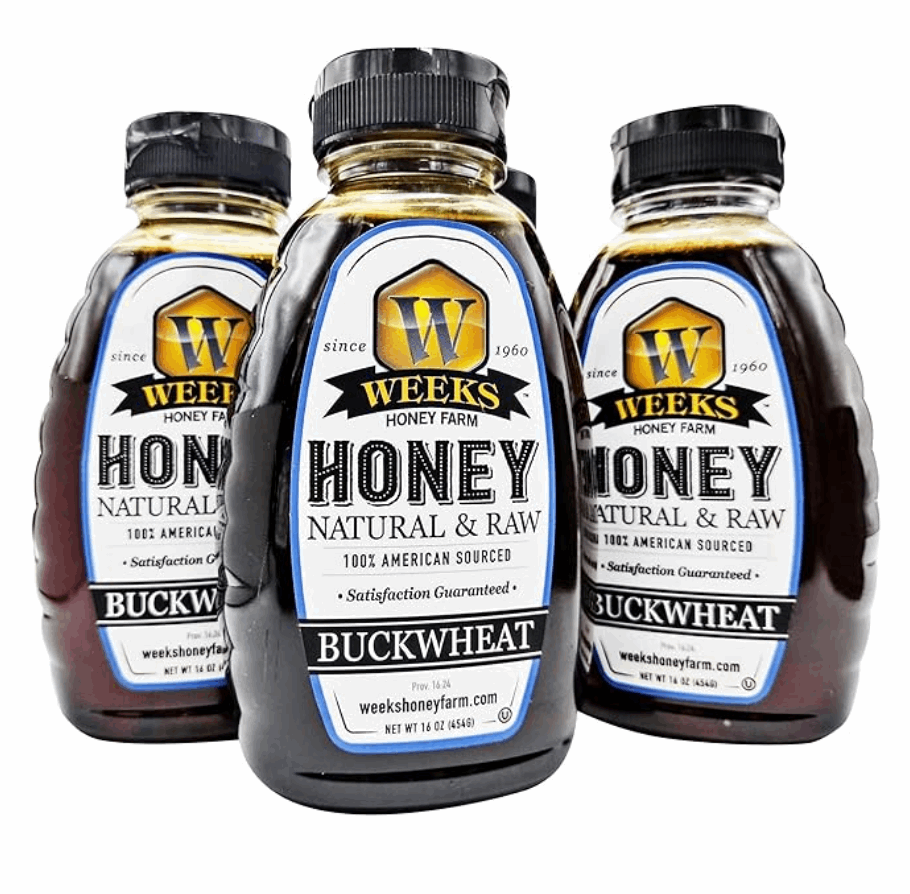 Four 16oz bottles of Weeks Honey Farm Raw Buckwheat Honey—pure, all-natural, antioxidant-rich, and dark with a robust molasses flavor. White, blue, and gold labels; black caps. Perfect for coffee, waffles, or BBQ sauce.