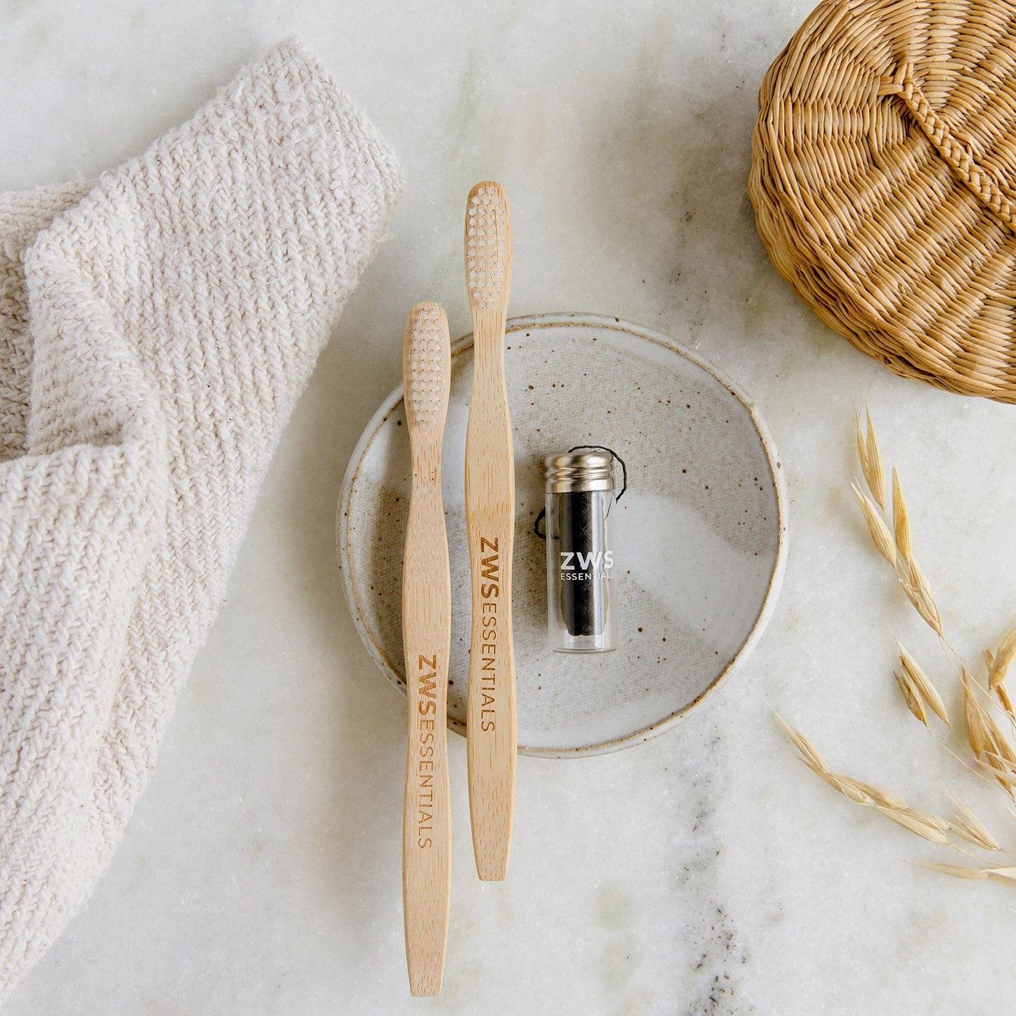 Two bamboo toothbrushes, bamboo charcoal floss, and dental care mini kit from ZeroWasteStore.com for eco-friendly oral care.