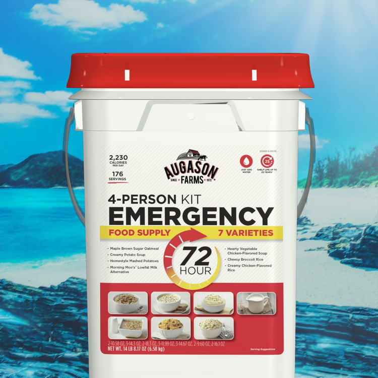 A white bucket labeled “Augason Farms 4-Person Emergency Food Supply Kit” with a red lid sits on a rocky beach. The kit advertises 2,230 calories per day, 176 servings, and 7 meal varieties for 72 hours.
