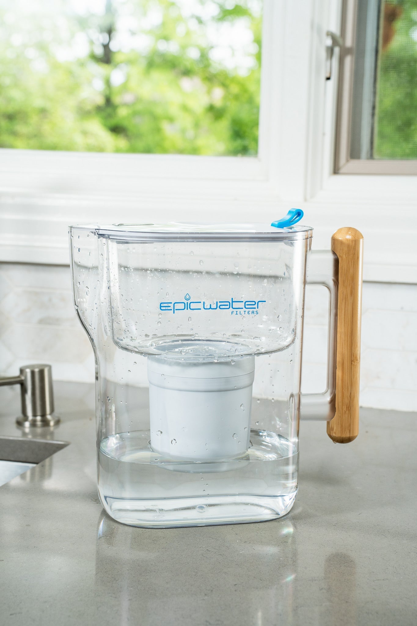 Epic Water Filters Pure XP Pitcher in red for reducing fluoride, PFAS, and parasites; shown with water filling the pitcher.