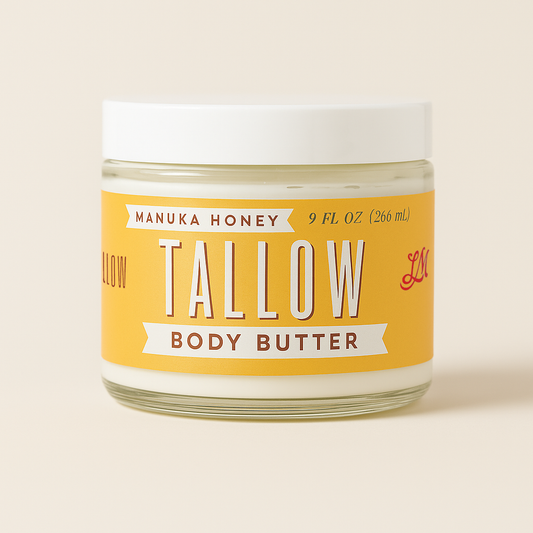 A glass jar of Lady May Tallow Manuka Honey & Rosehip Tallow Body Butter, 9 fl oz (266 mL), with a white lid and a yellow label featuring red and white decorative text.