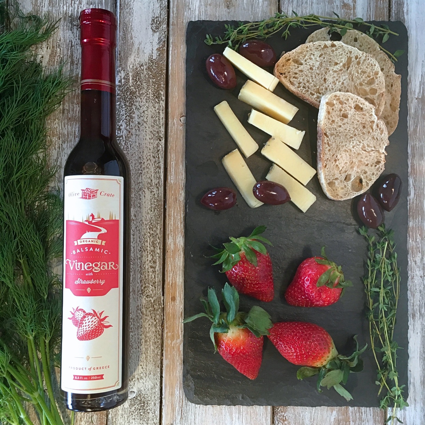 Olive Crate organic balsamic vinegar with strawberry in a glass bottle, showcasing fresh strawberries and dark balsamic vinegar inside