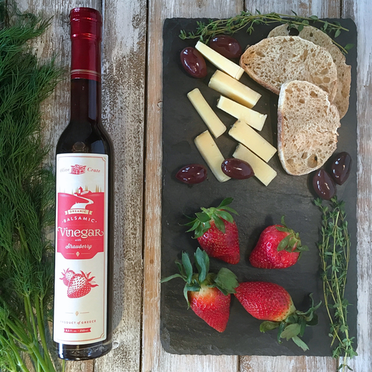 Olive Crate organic balsamic vinegar with strawberry in a glass bottle, showcasing fresh strawberries and dark balsamic vinegar inside