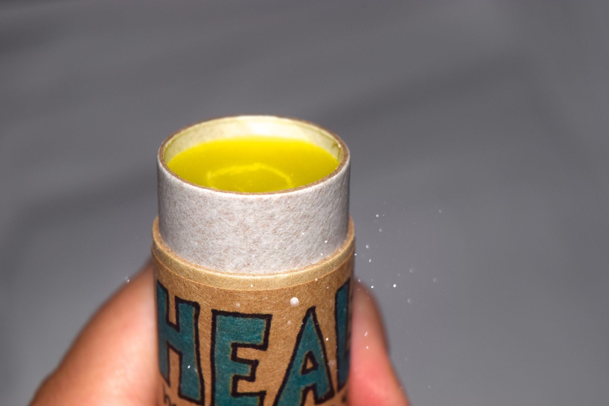 Plant Makeup Heal All Balm jar with a natural wooden lid, showcasing the skincare product in a clear glass container.
