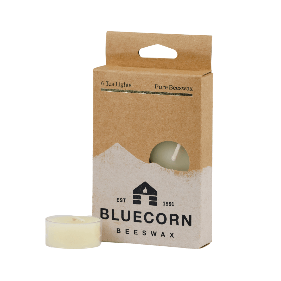Pure beeswax tea light candle from Bluecorn Candles, showing a small, round, natural beeswax tea light with a wick in a clear container.