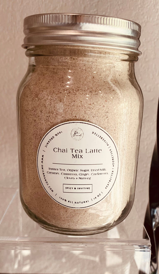 Creamy chai tea latte in a clear glass cup with cinnamon and spice, served hot, by Onic Brands LLC.
