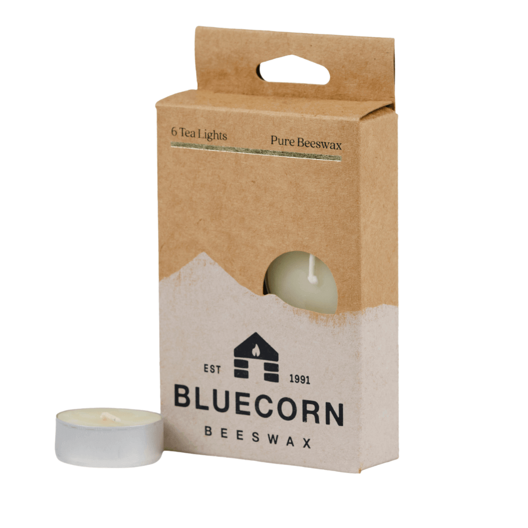 Two pure beeswax tea light candles from Bluecorn Candles, showing their small, round shape and natural honey-colored wax.