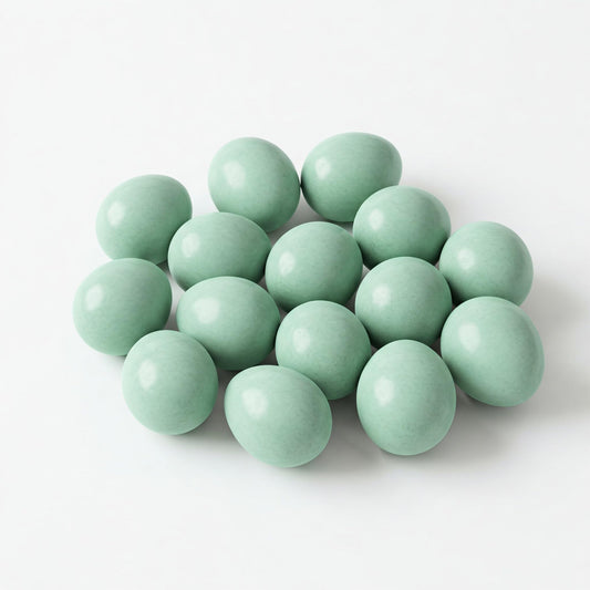 Two Celadon Coturnix hatching eggs from Quailz.com by Undique LLC, showing smooth, speckled surface and oval shape.