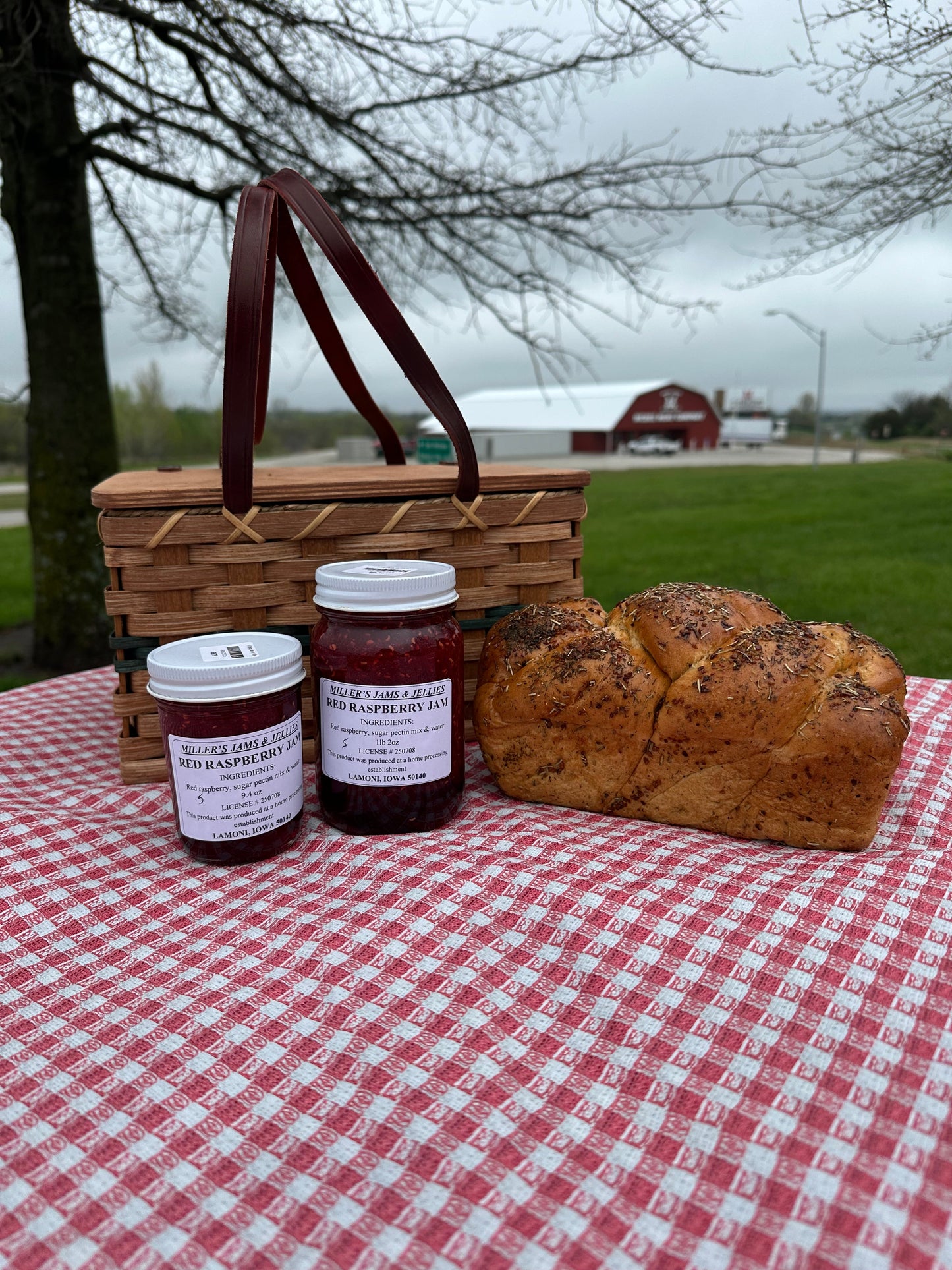 Amish Country Store Miller's Red Raspberry Jam jar with a red raspberry jam label on a wooden table