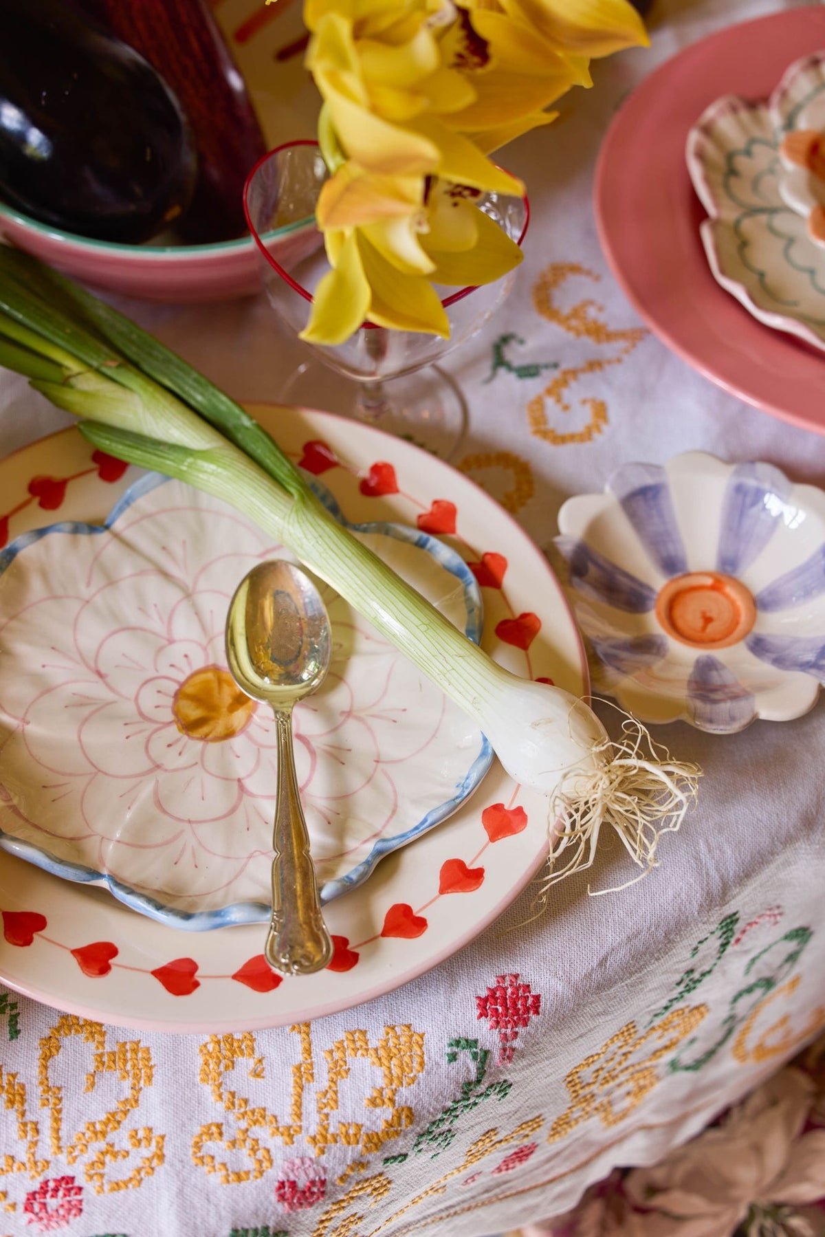 Ceramic flower-shaped side plate with blue border from Rice By Rice, featuring intricate floral design and vibrant ceramic finish.