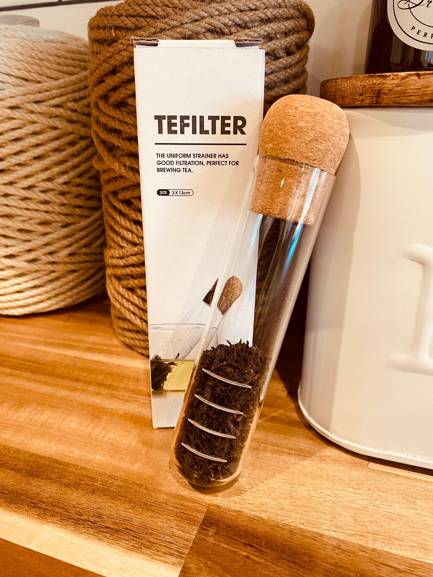 Onic Brands LLC TEFILTER tea test tube with a clear glass container and metal lid for brewing tea samples.