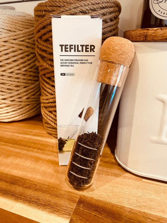 Onic Brands LLC TEFILTER tea test tube with a clear glass container and metal lid for brewing tea samples.
