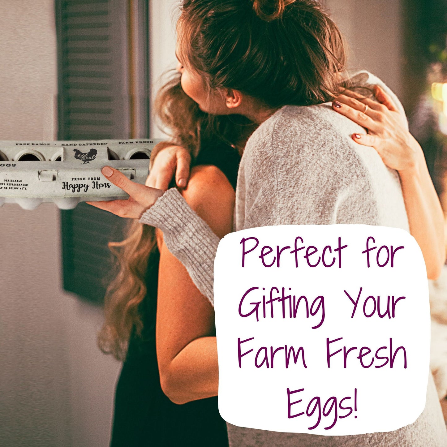 Two women hug as one hands a Henlay Laid Local Egg Carton by My Pet Chicken to the other. Adorable printed vintage design, available in packs of 25, 90, or 250—perfect for gifting your farm fresh eggs!.