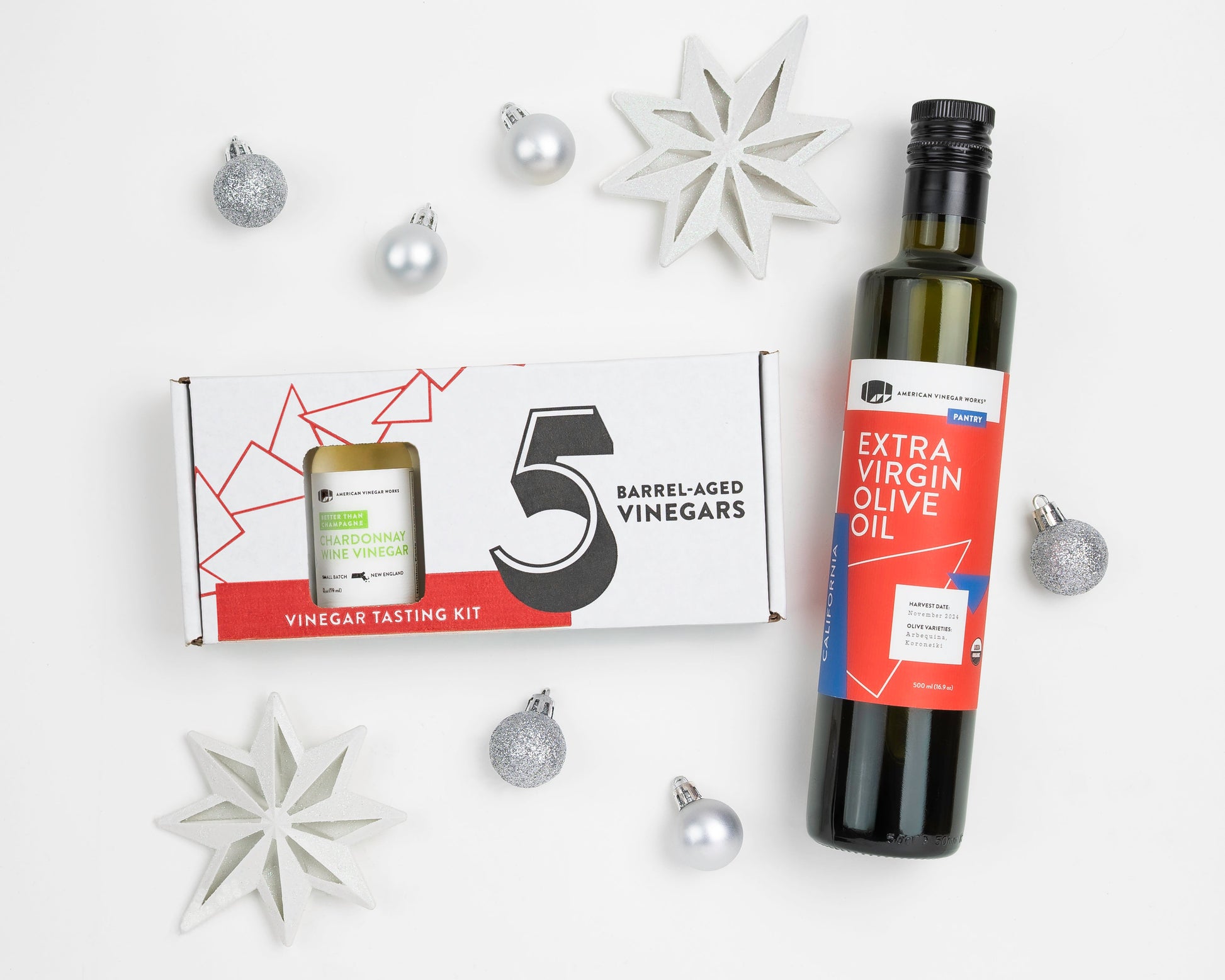 Assorted American Vinegar Works oil and vinegar sampler bottles arranged on a wooden surface for tasting.