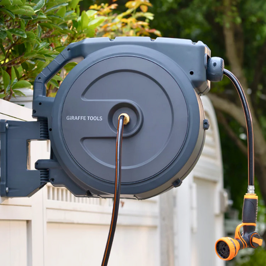 Giraffe Tools US retractable garden hose reel, 62 to 155 feet, with black and silver design, mounted in a garden setting
