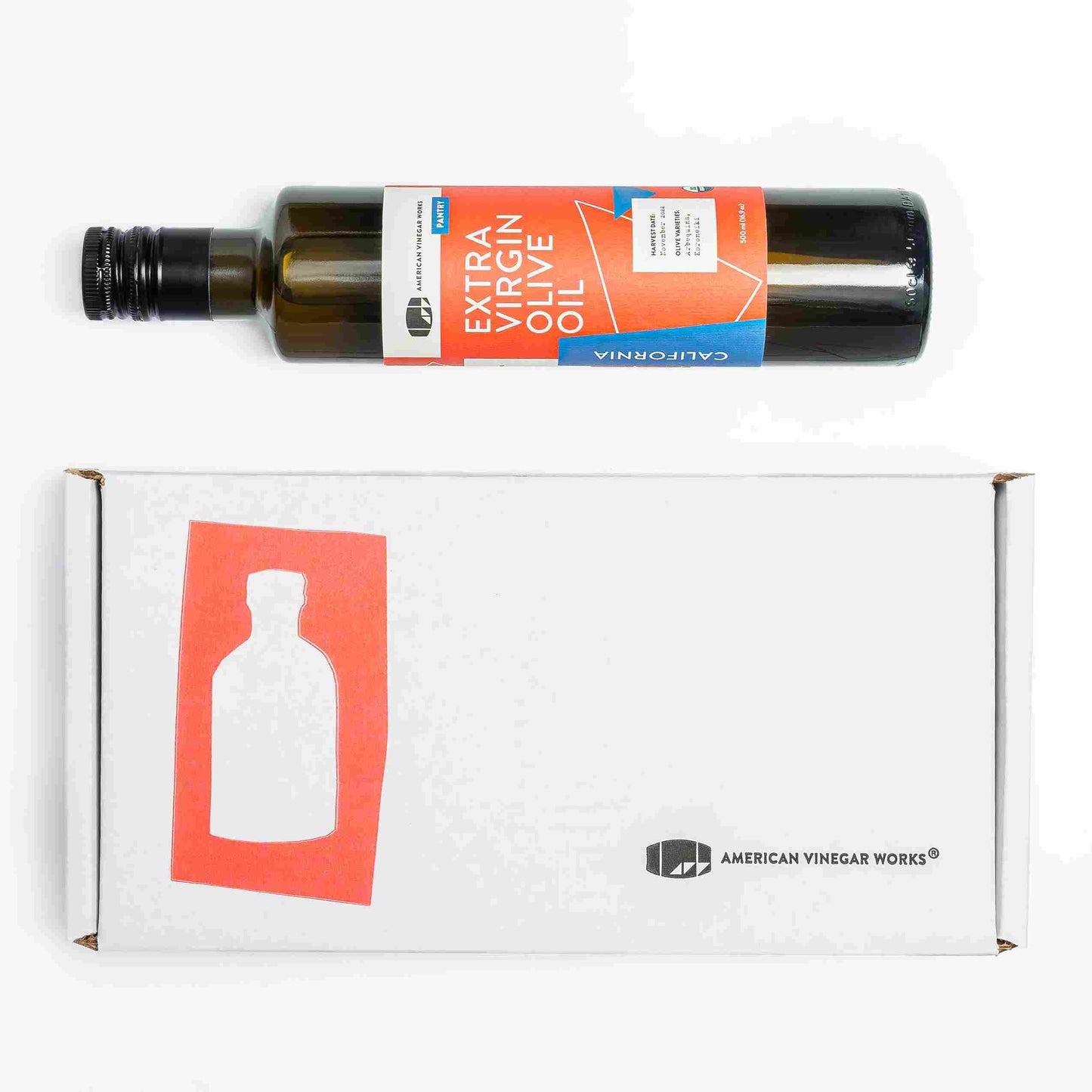American Vinegar Works vinegar set with extra virgin olive oil bottle and packaging box on a kitchen countertop.
