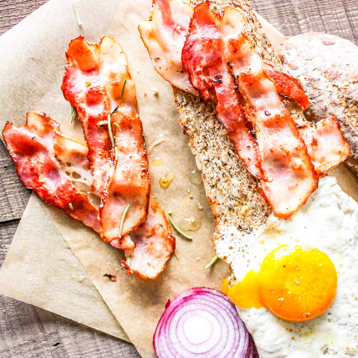 Award-winning nitrate-free bacon from Pig of the Month BBQ, perfect for bacon lovers' feast, shown sliced and cooked.