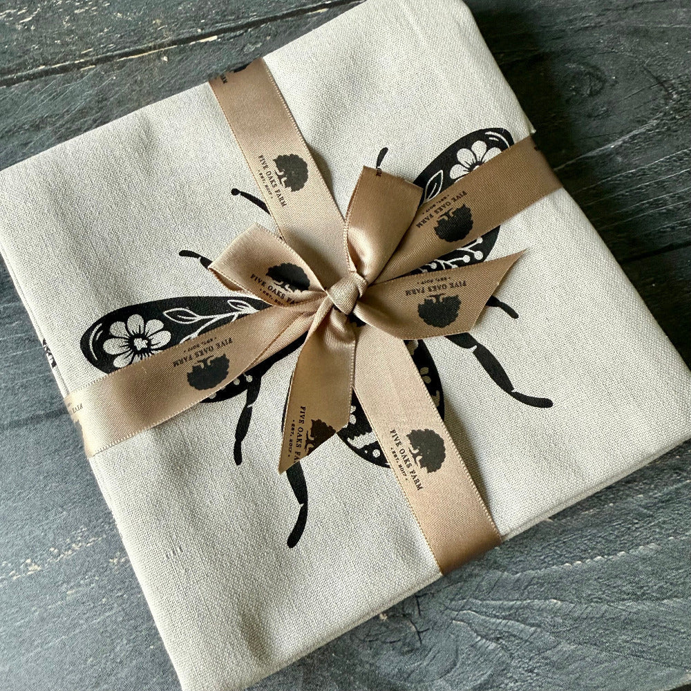 Set of five Oaks Farm hand towels with farm-inspired designs, soft cotton texture, and neutral colors in a cozy home setting.