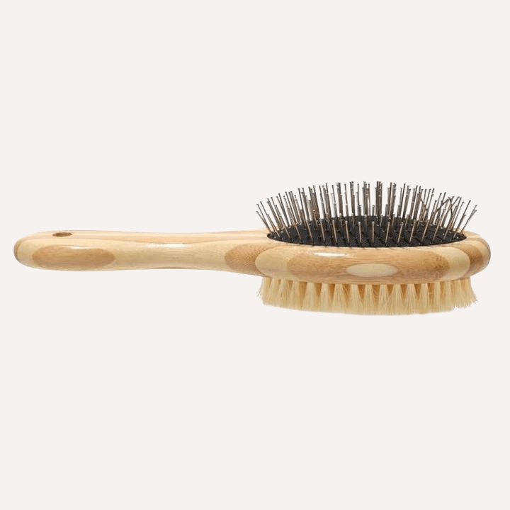 Two-sided Tilley + Me dog grooming brush with bristles and wire for shedding and detangling, featuring bamboo handle.