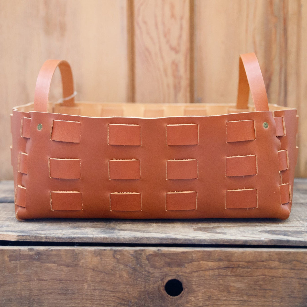 Large caramel leather woven basket by The Local Branch, showcasing a sturdy, handcrafted leather storage basket with woven details.