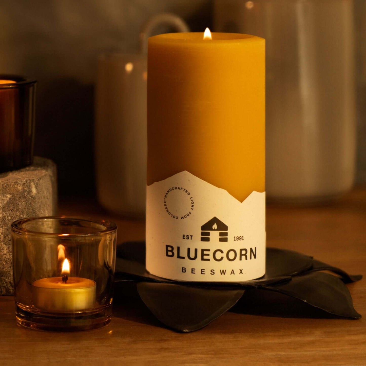 Pure beeswax pillar candles by Bluecorn Candles, featuring a tall candle and tea light in a glass holder, perfect for fall decor.